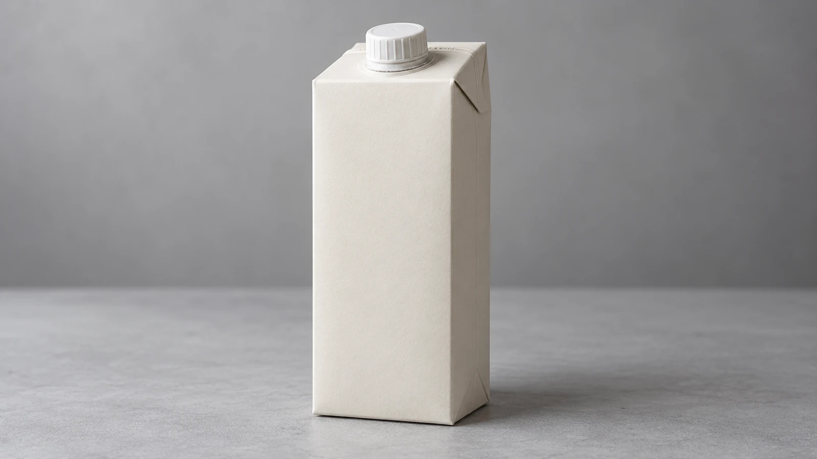 A single unbranded off-white beverage carton with a white screw cap on a neutral grey tabletop.